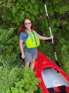 Jenny standing next to kayak
