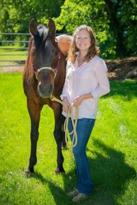 Photo of Laura Mengars standing next to horse