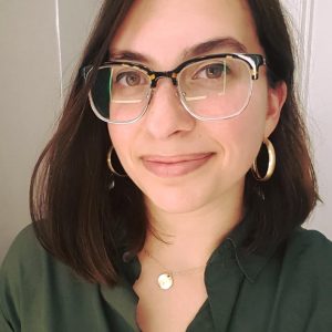 Mahalia Sobhani wearing glasses, gold earrings, and a green shirt.